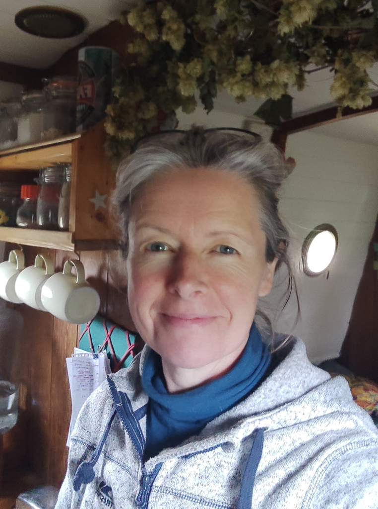 Rebecca standing in her narrowboat, sharing her journey into slow living, simple living, and intentional living and creating Simple Life Explorers